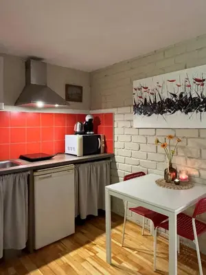 a kitchen with a white table and red walls at Little house in Kaunas