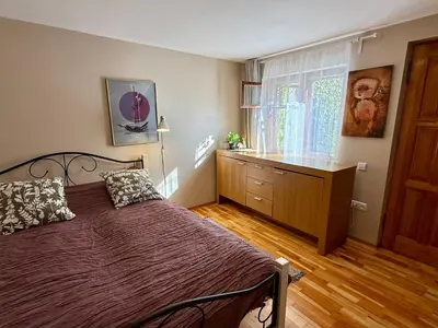 a bedroom with a bed and a dresser and a window at Little house in Kaunas