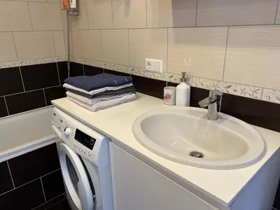 a bathroom with a sink and a washing machine at Your home - Spacious Apartment in City Center, with Balcony & Self Check-in in Vilnius
