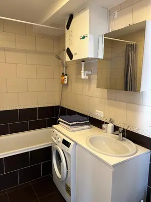 a bathroom with a washing machine and a sink at Your home - Spacious Apartment in City Center, with Balcony & Self Check-in in Vilnius