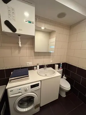 a small bathroom with a washing machine and a sink at Your home - Spacious Apartment in City Center, with Balcony & Self Check-in in Vilnius