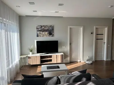 a living room with a couch and a television at Your home - Spacious Apartment in City Center, with Balcony & Self Check-in in Vilnius