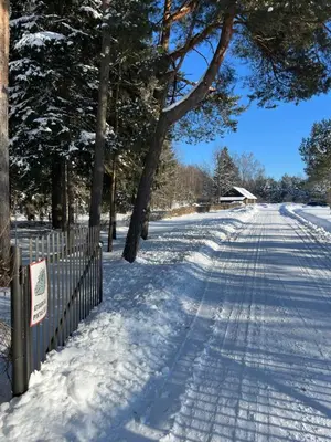 a snow covered road with trees and a fence at Vila Loreta - namelis su pirtimi in Dūdorynė