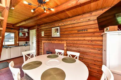 a kitchen and dining room with a table and chairs at Vila Loreta - namelis su pirtimi in Dūdorynė