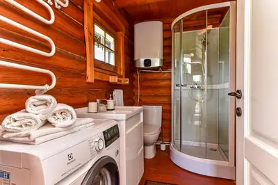 a bathroom with a washing machine and a toilet at Vila Loreta - namelis su pirtimi in Dūdorynė