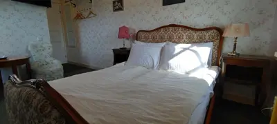 a bedroom with a bed with white sheets and pillows at Labanoro troba in Labanoras