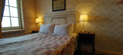 a bedroom with a bed with pillows and two lamps at Labanoro troba in Labanoras