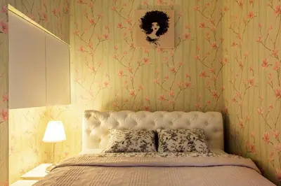 a bedroom with a bed with pink floral wallpaper at Apartment Gabriele in Old Town Vilnius in Vilnius