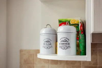 two white cups on a shelf in a kitchen at Apartment Gabriele in Old Town Vilnius in Vilnius