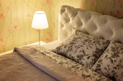 a bedroom with a white bed with pillows and a lamp at Apartment Gabriele in Old Town Vilnius in Vilnius