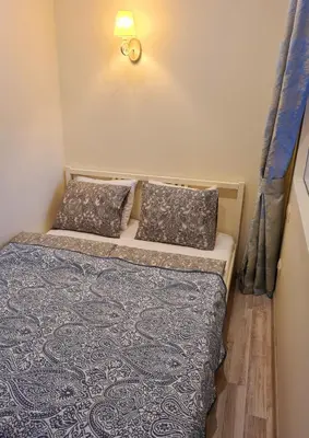 a small bedroom with a bed with a blue blanket and pillows at M.K. Čiurlionis 7 in Vilnius
