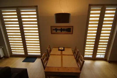 a dining room with a wooden table and chairs at Apartment Hanna in Druskininkai