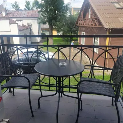 a table and chairs on a balcony with a view of a car at Apartment Hanna in Druskininkai