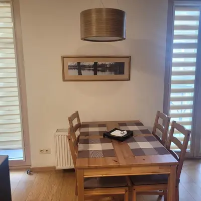 a dining room with a wooden table and chairs at Apartment Hanna in Druskininkai