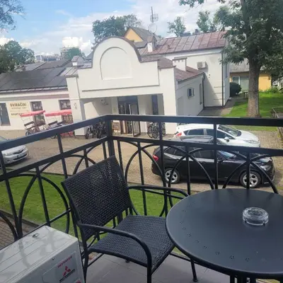 a balcony with two chairs and a table and a car at Apartment Hanna in Druskininkai