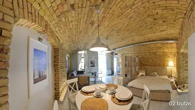 a room with a bed and a table with chairs at Six Apartment Simona in Vilnius