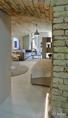 a room with a bed and a brick wall at Six Apartment Simona in Vilnius