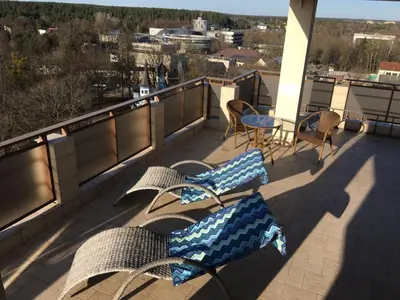 two chairs and a table on a balcony with a view at Panorama Apartment in Druskininkai