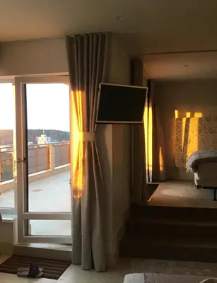 a bedroom with a window with a view of a balcony at Panorama Apartment in Druskininkai