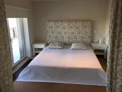 a bedroom with a large white bed and a window at Panorama Apartment in Druskininkai