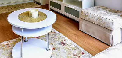 a living room with a white table and a rug at Stilingi apartamentai su virtuve Trakų miesto centre in Trakai