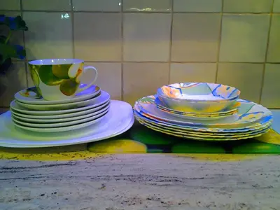 a pile of plates and a cup on a table at Stilingi apartamentai su virtuve Trakų miesto centre in Trakai