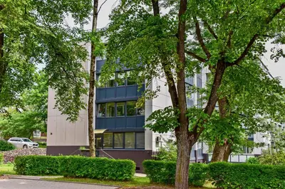 an office building with trees in front of it at Stilingi apartamentai su virtuve Trakų miesto centre in Trakai