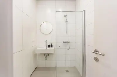 a white bathroom with a shower and a sink at #stayhere - Modern Designer 1BDR Apartment in Artistic District in Vilnius