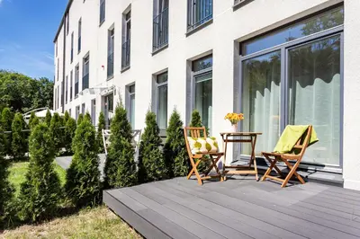 a wooden deck with two chairs and a table at #stayhere - Modern Designer 1BDR Apartment in Artistic District in Vilnius