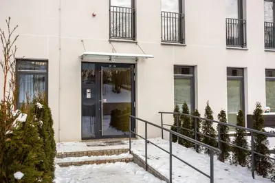 a building with a glass door in the snow at #stayhere - Modern Designer 1BDR Apartment in Artistic District in Vilnius