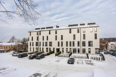 a large white building with cars parked in the snow at #stayhere - Modern Designer 1BDR Apartment in Artistic District in Vilnius