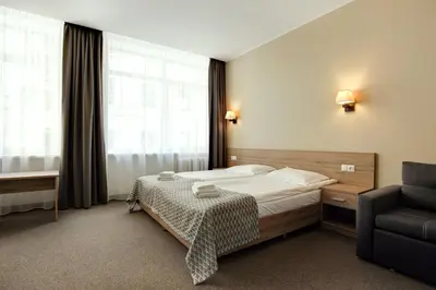 a hotel room with a bed and a chair at Old Town Trio in Vilnius