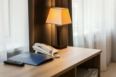 a desk with a phone and a lamp on it at Old Town Trio in Vilnius