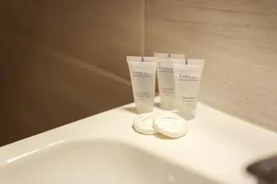 a white sink with two bottles of moisturizers on it at Old Town Trio in Vilnius