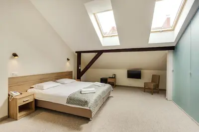 a bedroom with a bed and two windows at Old Town Trio in Vilnius