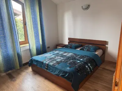 a bedroom with a bed with a blue comforter and a window at K-Town - Cozy Apartment Near the City Center in Kaunas