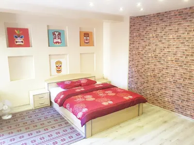 a bedroom with a bed and a brick wall at K-Town - Cozy Apartment Near the City Center in Kaunas