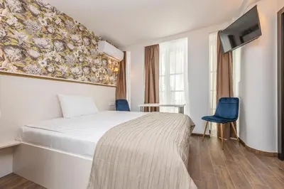 a bedroom with a bed and a tv on a wall at Kesminta Apartments in Vilnius