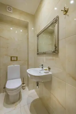 a bathroom with a toilet and a sink and a mirror at Kesminta Apartments in Vilnius