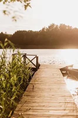 a wooden bridge over a body of water at Beržų namelis - Birch cabin in Kučiūnai