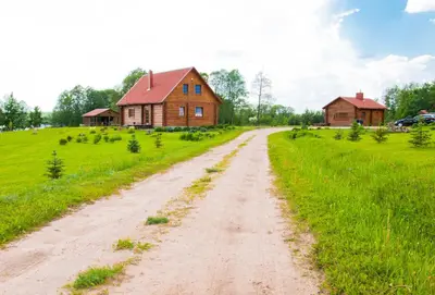 a dirt road in front of a farm house at Adomo Sodyba in Dubingiai