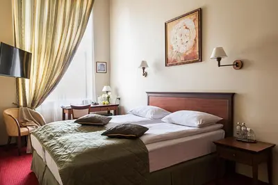 a hotel room with a bed with two pillows on it at Conviva in Panevėžys