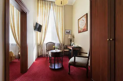 a hotel room with a table and chairs in a room at Conviva in Panevėžys