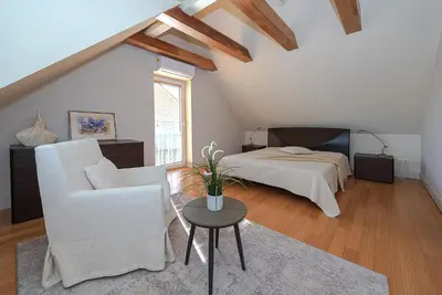 a bedroom with a bed and a chair and a table at Domido Villa in Trakai