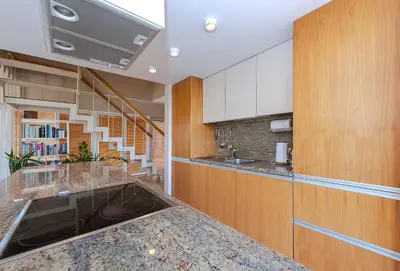 a kitchen with a counter with a sink and a staircase at Domido Villa in Trakai