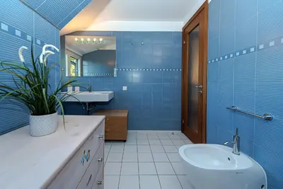 a blue bathroom with a toilet and a sink at Domido Villa in Trakai
