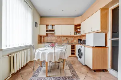 a kitchen with a table with chairs and a washing machine at Old Town Apartment Antokolskio in Vilnius