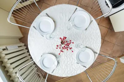 a white table with glasses and flowers on it at Old Town Apartment Antokolskio in Vilnius