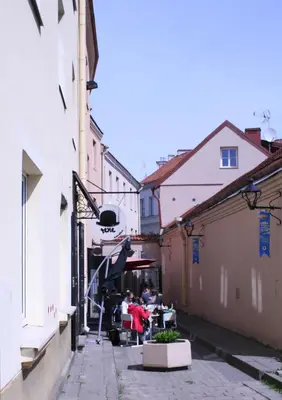 an alley with people sitting at a table in a building at Old Town Apartment Antokolskio in Vilnius