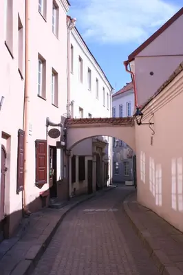 an alley with an archway between two buildings at Old Town Apartment Antokolskio in Vilnius